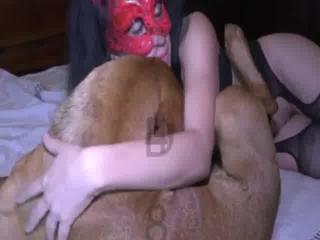 Masked girl is recorded engaging in sexual acts with an erect dog